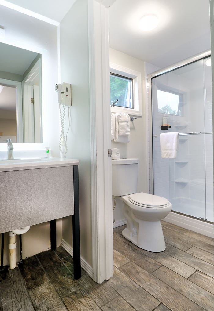 A clean and modern bathroom with a sink, toilet, and shower.